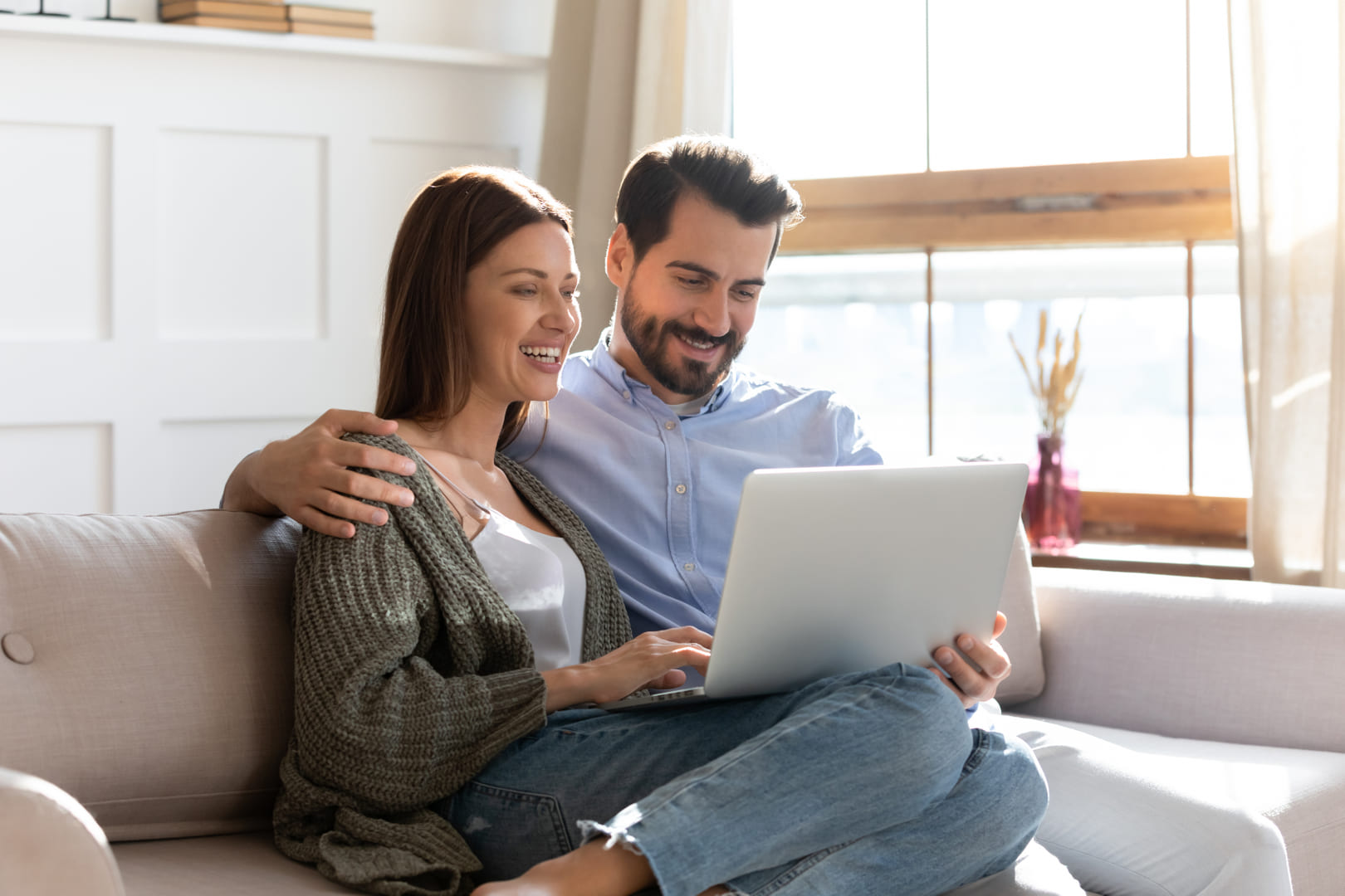 Photo d'un couple devant un ordinateur, se renseignant sur l'assurance-vie